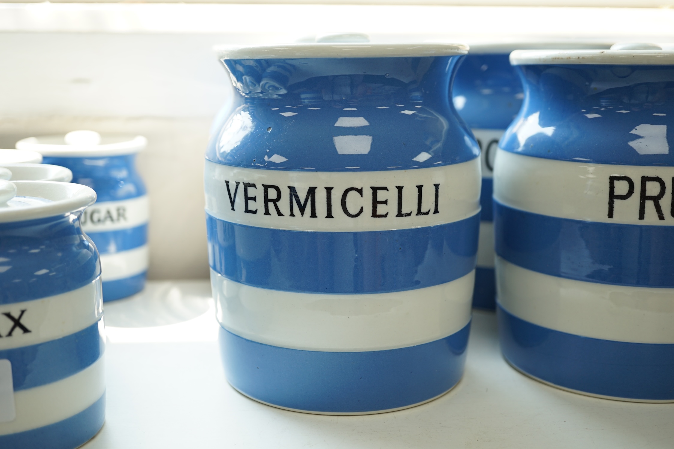 T.G.Green Cornish Kitchenware, seven 14cm lidded storage jars to include Vermicelli, Macaroni, Treacle, Biscuits and Prunes with a smaller Biscuit jar and cover, mainly Green Church marks. Condition - poor, fair and good